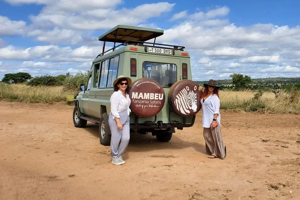 Mambeu guests beside the branded safari vehicle